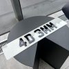 A 4D 3mm number plate with raised black acrylic characters on a white plate, resting on a dark, circular table.