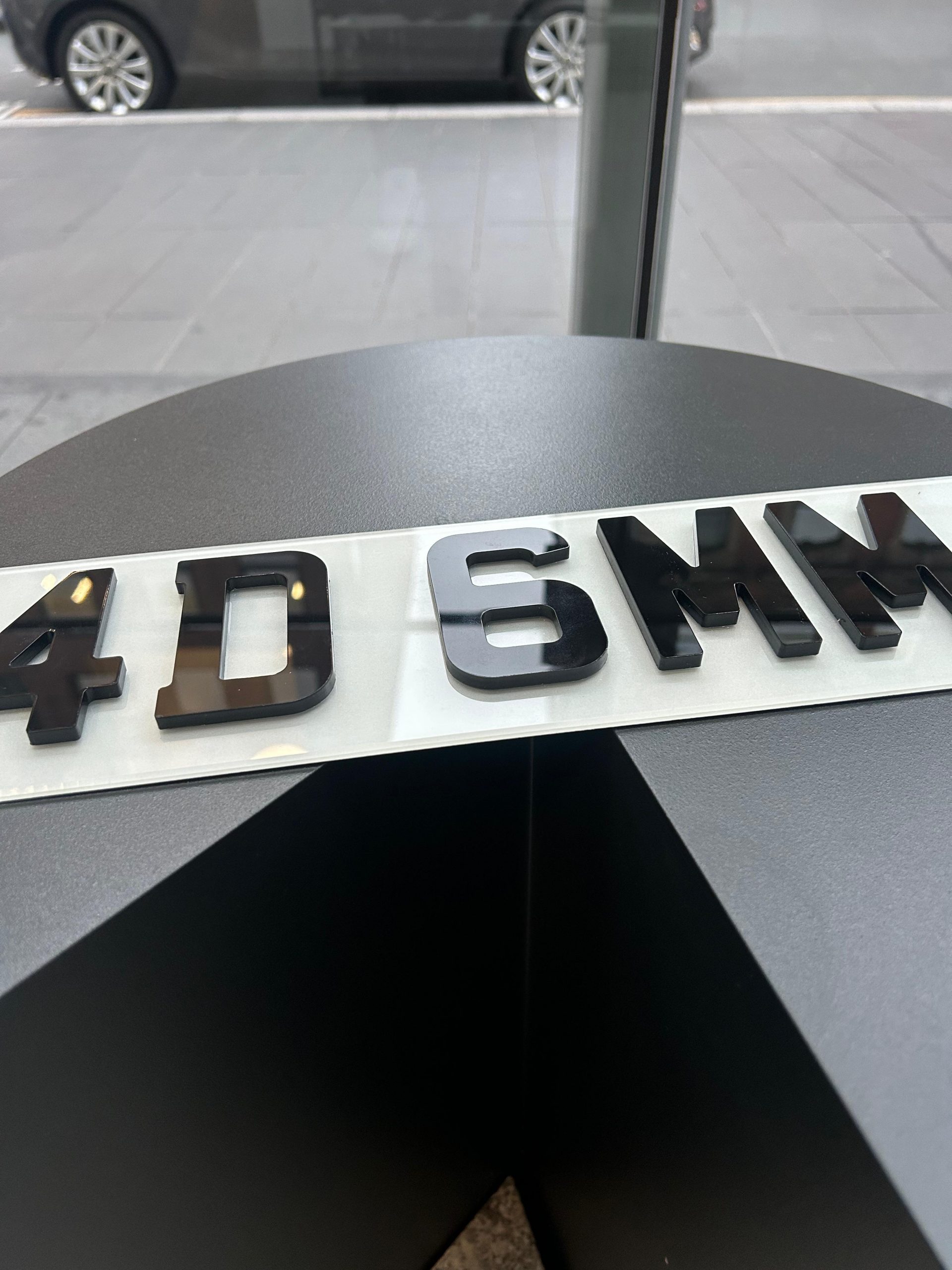 4D 6mm number plate, 4D number plates, 3D number plates, best number plate maker An angled view of a 4D 6mm number plate, showing the raised, laser-cut acrylic characters on a white plate.