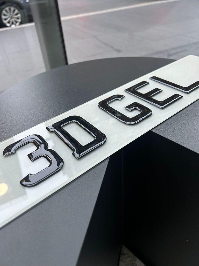 Close-up of glossy black 3D Gel number plate lettering reading '3D GEL' on a white background.